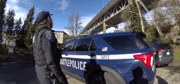 Seattle police officer beside patrol SUV 