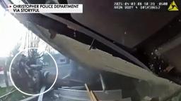 Christopher police officers and neighbor lift pulling the trapped firefighter from under the collapsed roof
